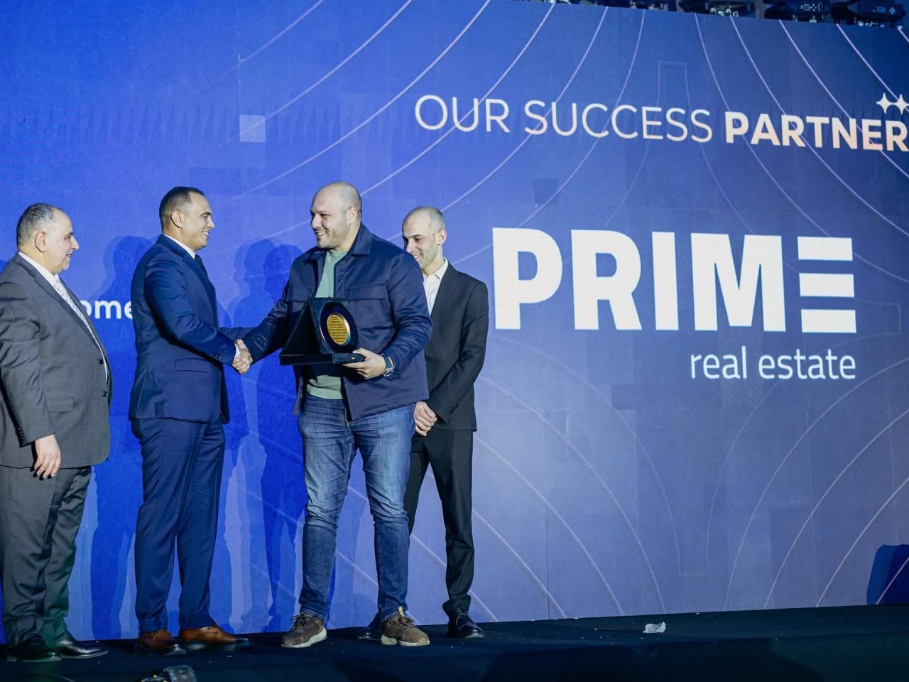 Prime Real Estate receiving an “Our Success Partner” award on stage